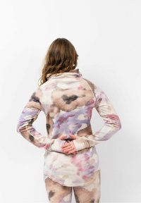 Langärmliges Oberteil aus weichem, dehnbarem Material mit einem Aquarellmuster in Beigetönen, Rosa und Lila; umfasst einen hohen Kragen und Daumenlöcher.