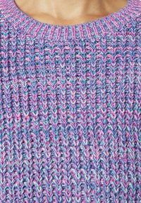 Maglione lavorato a maglia in una miscela di filati rosa e blu. Presenta un colletto rotondo a costine e un motivo a zig zag diagonale texturizzato.