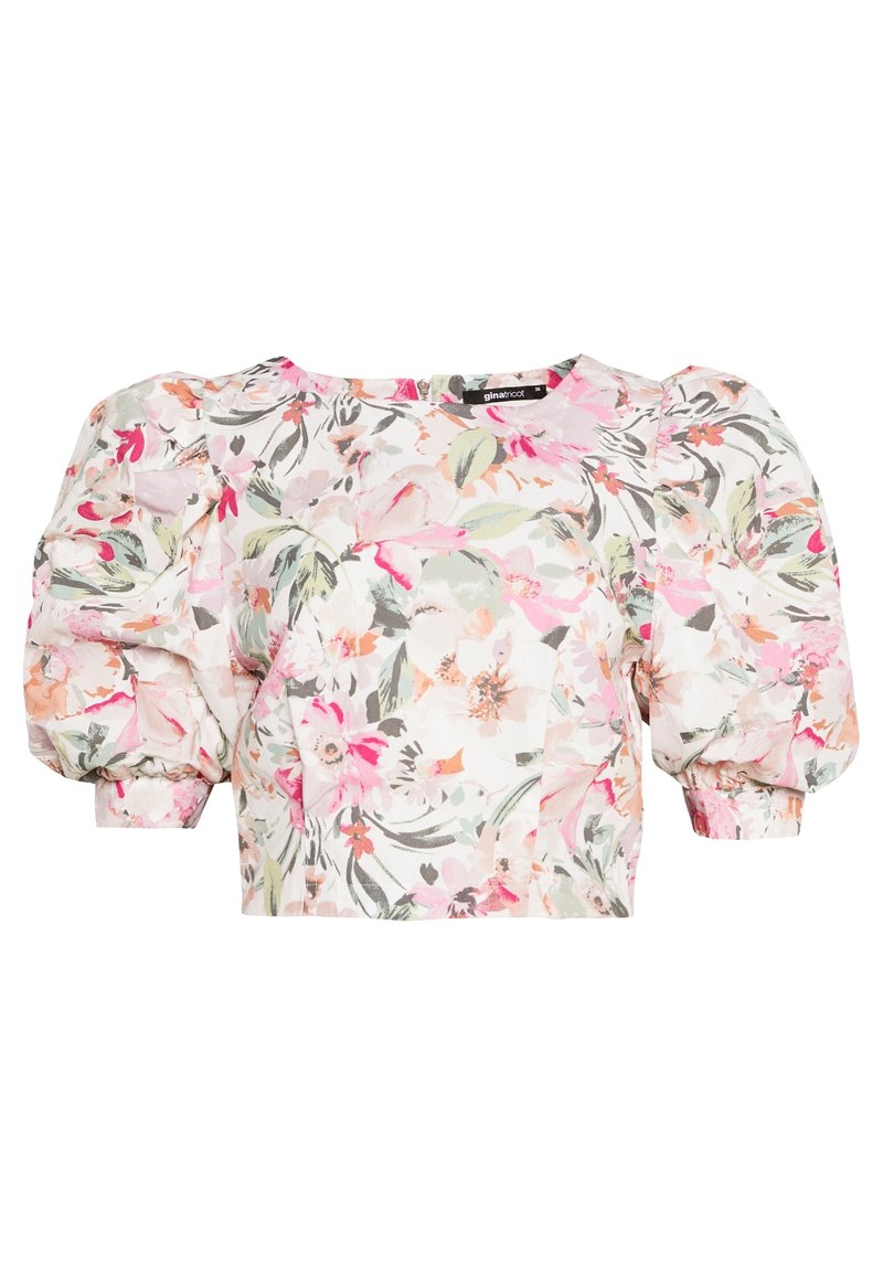 Blommig crop top med korta puffärmar, med rosa, gröna och vita mönster på lätt tyg. Fyrkantig halsringning och lätt lyster.