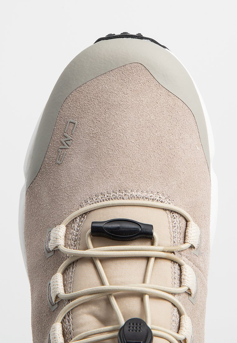 Helle beige Wanderschuhe mit einer glatten Gummikappe, einem strukturierten Wildleder-Obermaterial, elastischen Schnürsenkeln und einem schwarzen Knoten für eine sichere Anpassung.