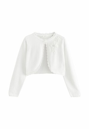 Cardigan court blanc à manches longues avec bords festonnés et broderie florale sur le côté gauche de la poitrine, fermeture par boutons au niveau du col.