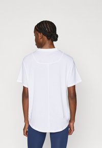 Λευκό T-shirt με κοντά μανίκια, στρογγυλεμένο τελείωμα και διακριτικές ραφές. Απαλή υφασμάτινη υφή, άνετη εφαρμογή, χωρίς σχέδια και στρογγυλή λαιμόκοψη.