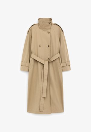 Trench-coat beige à double boutonnage sur le devant, taille ceinturée, col, épaulettes et bracelets aux poignets. Tissu lisse et coupe droite.