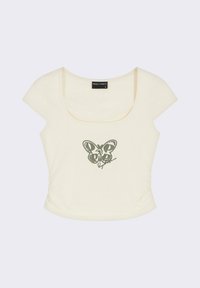 Haut crème à manches courtes avec un décolleté arrondi, présentant un graphique de papillon vert et un texte en cursive au centre. Tissu doux et extensible.
