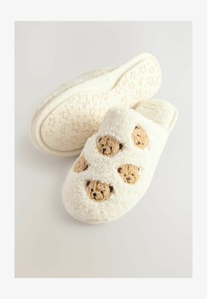 Hvide fluffy tøfler med bjørneansigt, blød tekstur og en polstret sål med stjerner og måner mønster.