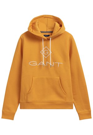 Musztardowa bluza z kapturem z kieszenią z przodu, białymi sznurkami i białym logo "GANT" umieszczonym centralnie na piersi z diamentową ramką wokół litery "G".