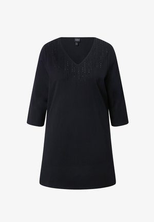 Zwarte V-hals top met driekwart mouwen, voorzien van decoratieve verticale studs langs de halslijn. Gladde textuur en een ontspannen pasvorm.