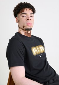 Nike Sportswear AIR GRAPHIC TEE - Marškinėliai su spaudiniu - black/metallic gold