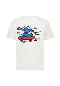 T-shirt en coton blanc avec un graphique bleu représentant un skateur sur un skateboard rouge, avec des lignes de mouvement noires et des roues jaunes au dos.