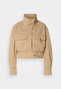 Κοντό μπεζ σακάκι από απαλό βαμβάκι με ψηλό γιακά, κούμπωμα με κουμπιά τύπου snap και δύο τσέπες στο ύψος του στήθους. Διαθέτει λεία, ματ υφή.