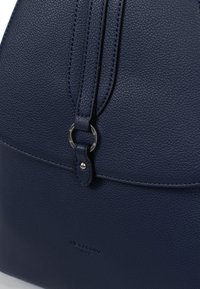 Borsa a mano in pelle blu navy con finitura testurizzata, caratterizzata da una forma arrotondata, tracolla regolabile e dettagli in metallo. Logo impresso sul davanti.