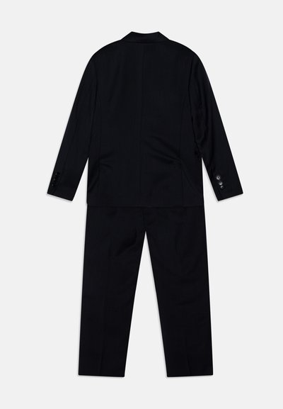 Must sõna on õmmeldud mustade detailidega ülikond, mis koosneb jakist, millel on lõigatud klappidega kaelus, ja pükstest. Omadusteks on nupud ja sile tekstuur.