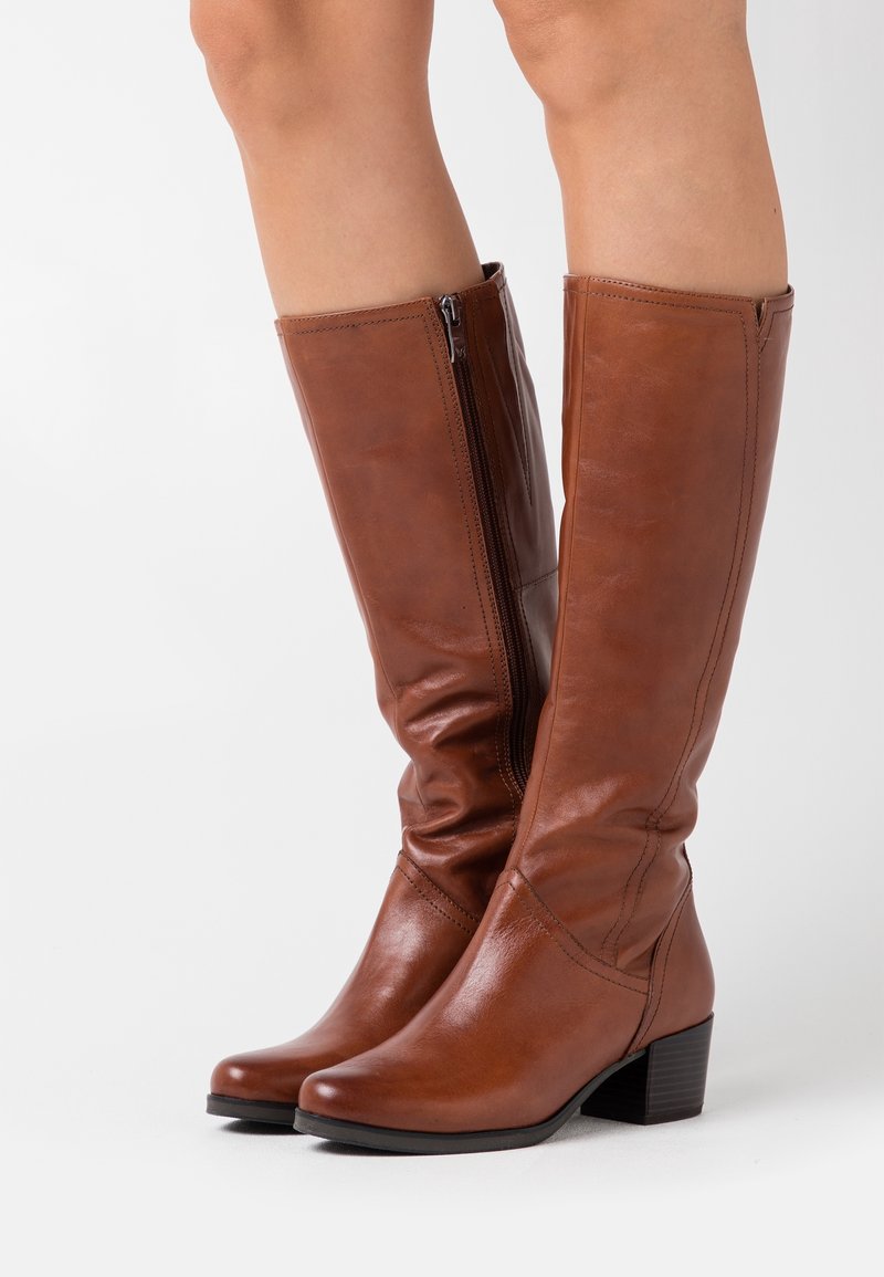 Botas de cuero marrón hasta la rodilla con cierre de cremallera, diseño ligeramente ajustado, acabado texturizado y tacón bajo en bloque.