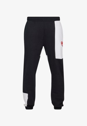 Zwarte sweatpants met witte zijpanelen, elastische tailleband en een rode logoaccent. Gemaakt van zachte stof met een losse pasvorm.