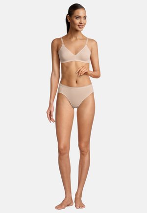 Nude seamless bralette with adjustable straps and matching high-waisted panties. Smooth fabric, soft texture, and minimalist design.