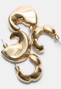 Náušnice s kruhovým dizajnom v zlatom odtieni s hladkým, reflexným povrchom a robustným, zakriveným dizajnom so zapínaním na pletacie kolíky.