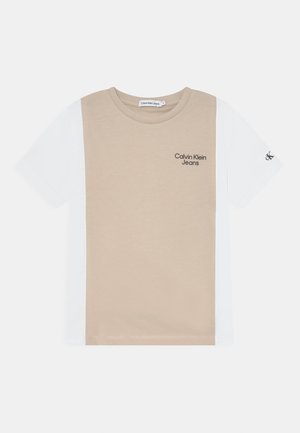 Koszulka z krótkim rękawem w stylu colorblock z beżowym środkiem, białymi rękawami, logo "Calvin Klein Jeans" na piersi oraz napisem "cK" na lewym rękawie.