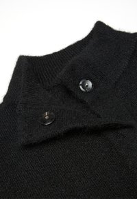 Maglione di lana nera con colletto alto, dotato di due bottoni neri sul colletto e un morbido motivo a maglia testurizzato.