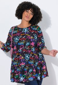 Tunique noire avec des textes graphiques multicolores et des motifs floraux. Présente des manches trois-quarts et une taille ample et froncée.