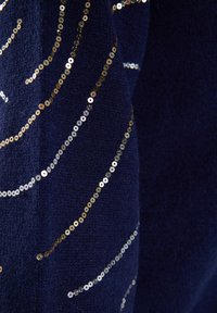 Tessuto navy con superficie testurizzata, caratterizzato da linee curve di paillettes dorati e argentati che aggiungono dimensione e brillantezza.