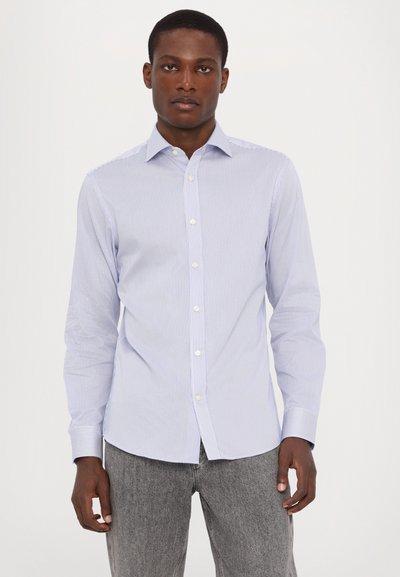 Camicia a righe blu chiaro con colletto button-down, maniche lunghe e bottoni bianchi. Il tessuto ha una texture liscia; vestibilità sartoriale.