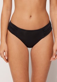 Black bikini bottom with gathered side detailing. Features a smooth, stretchy fabric and medium-rise cut for coverage.