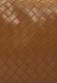 Brown woven leather material with a textured, diamond-patterned surface, showcasing a smooth finish and uniform square shapes.