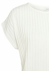 Vit ribbad stickad kortärmad topp med rund halsringning och något figursydd form.