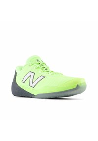 Lystne neongrøn New Balance sportsko med sort sål og stort hvidt "N" logo på siden, præsenteret mod hvid baggrund.