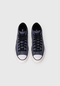 Sneakers de lona azul-marinho com atacadores pretos, biqueira em borracha branca e sola em borracha texturizada. Apresenta um design de cano baixo e uma marcação mínima.