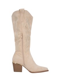 Bota de cowboy de ante beige con adornos, altura hasta la mitad de la pantorrilla, punta afilada y un tacón apilado con acentos dorados. Cierre de cremallera en el lado.