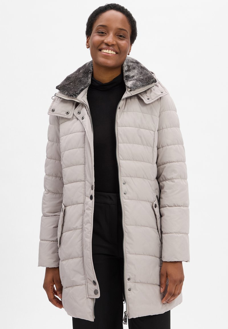 Lichtgrijze gewatteerde jas met een kraag van bont, ritssluiting en drukknopen. Beschikt over zijzakken en een gestikte textuur.