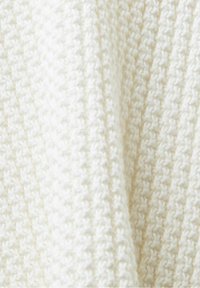 Tessuto di maglione lavorato a maglia in off-white, caratterizzato da un motivo testurizzato con un aspetto morbido e accogliente. Dettagli di intreccio evidenti.