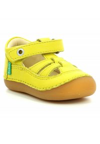 Geel leren sandaal voor peuters met klittenbandsluiting, gesloten neus, rubberen zool en merklabel aan de zijkant.