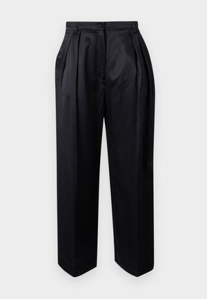 Juodos, aukšto liemens kelnės pagamintos iš lygaus audinio, su prigludusiais klostėmis, plačiomis kojomis ir tiesiu kirpimu su šiek tiek siaurėjančiais galais.