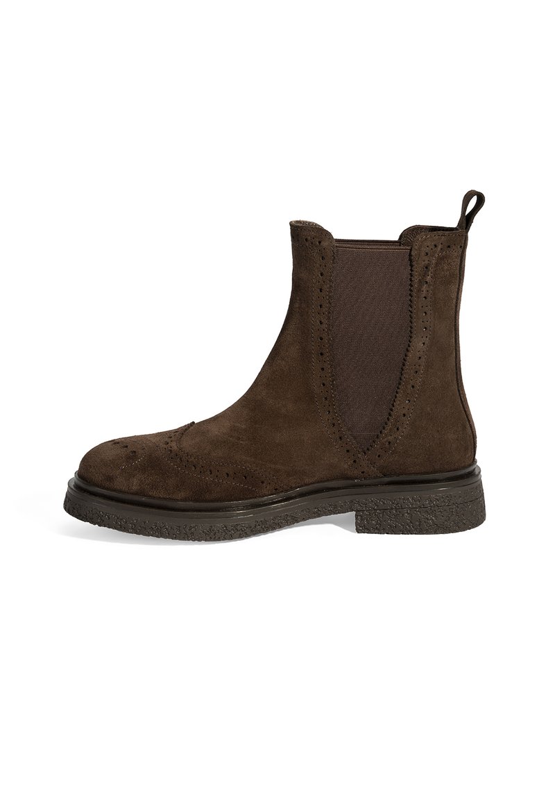 Bottines Chelsea en daim marron avec des panneaux élastiques, des détails de brogue le long des bords et une semelle en caoutchouc noir texturé. Hauteur de cheville basse.
