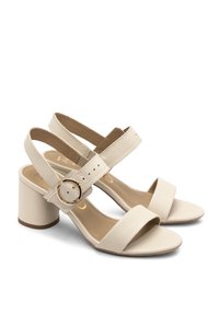 Beige plokk-heeled sandaalid, millel on tekstuuriga nahast pealne, sisaldades kahte laia rihma ja ümmargust kuldse tooni pandlat.