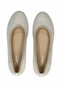 Bailarinas beige con parte superior de tela texturizada, puntera redonda y plantilla acolchada con perforaciones. Marca visible en la plantilla.
