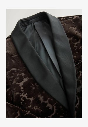 Tmavě hnědý sametový blazer s květinovým vzorem, s hladkým černým saténovým límcem a vnitřním podšíváním, zvýrazňující bohatou texturu a detail.