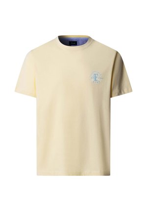 Camiseta crema de manga corta con cuello redondo, con pequeño logo circular azul en el pecho izquierdo y forro interior del cuello a rayas.