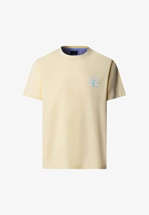 Camiseta crema de manga corta con cuello redondo, con pequeño logo circular azul en el pecho izquierdo y forro interior del cuello a rayas.