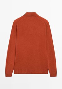 Pomarańczowy sweter dziany z kołnierzykiem, długimi rękawami oraz prążkowanym wykończeniem u dołu i na mankietach. Gładka tekstura, luźny krój i brak widocznych wzorów.