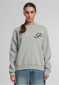 Sudadera gris claro de gran tamaño en tejido de punto, con un logo marrón bordado en el pecho y puños y bajo acanalados.