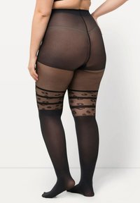 Calze trasparenti nere fin sopra il ginocchio con una fascia decorata da macchie di leopardo. Texture liscia, design a vita alta e finitura opaca.