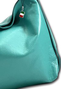 Sac en cuir turquoise avec une texture lisse, doté d'un petit charm en forme de drapeau italien accroché par un fermoir en argent. Le sac présente un design doux et plissé.