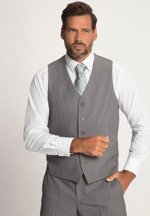 Gilet grigio in tessuto texturizzato, con cinque bottoni e colletto a punta, abbinato a una camicia bianca e una cravatta a fantasia.