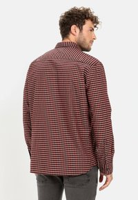 Red and black checkered shirt with long sleeves, button-up front, and a classic collar. Fabric appears soft with a smooth texture.