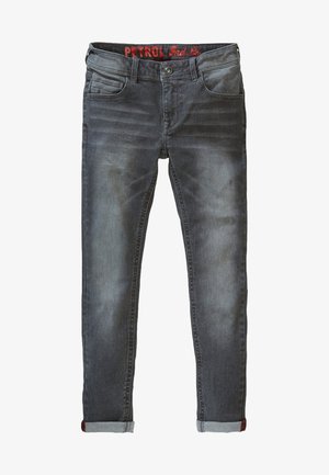 Jeans in denim grigio con vestibilità slim, caratterizzati da un orlo risvoltato. Abbinati a sneaker alte bianche con dettagli rossi. Design semplice, senza motivi visibili.