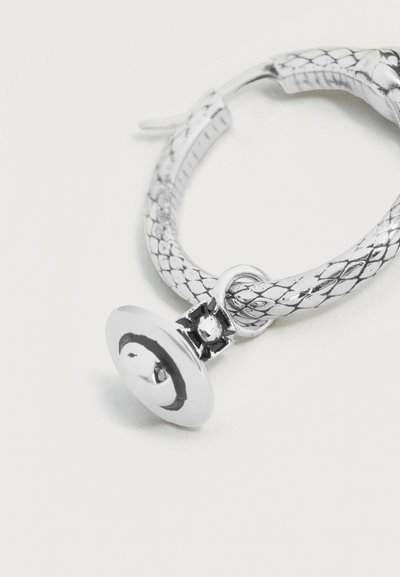 Ασημένιο σκουλαρίκι κρίκος με υφή φιδιού και στρογγυλό, κοίλο γούρι προσαρτημένο με μικρό δαχτυλίδι.