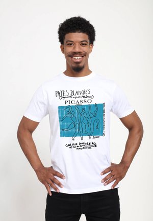 T-shirt en coton blanc avec un graphisme de Picasso sur un fond bleu, comprenant un dessin en ligne noire de personnages, ainsi que du texte et des détails en bas.